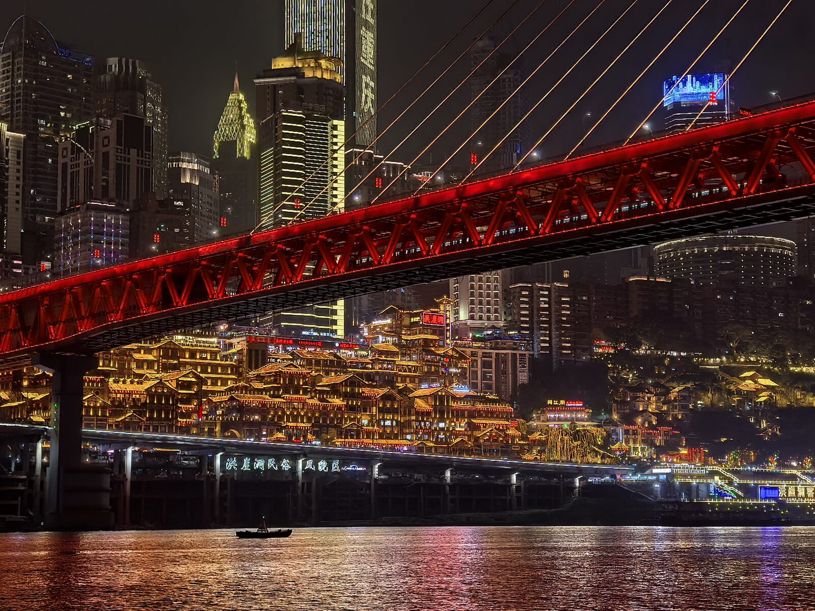 灯火通明的红色跨江大桥与吊脚楼群夜景
